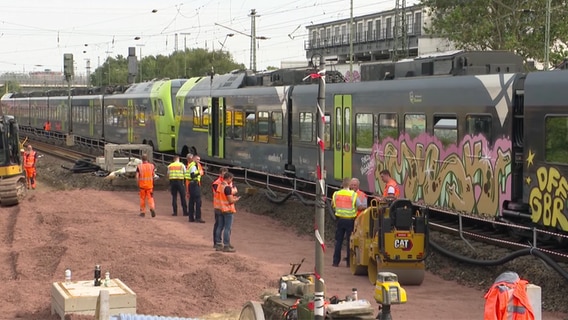 Polizei und Bahnmitarbeiter stehen nach einem Unfall mit einer Oberleitung auf einer Bahnstrecke © NDR 
