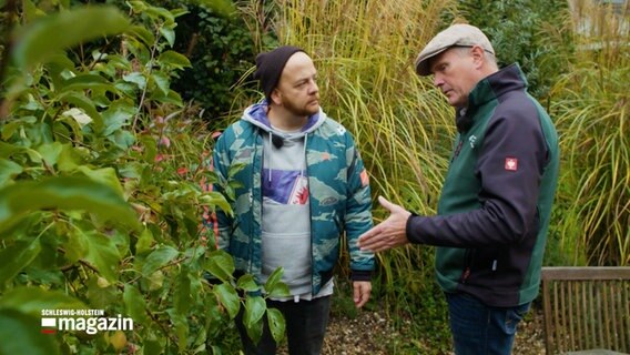 NDR Reporter Samir Chawki (l.) steht mit dem Gartenexperten Thomas Balster (r.) in einem Garten © NDR Schleswig-Holstein Magazin 