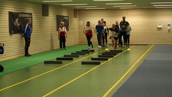 Sportler und Sportlerinnen trainieren für die Special olympics auf einer Laufbahn. © NDR Foto: Doreen Pelz