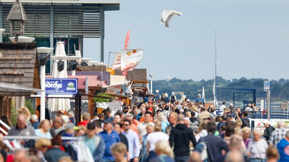 Zahlreiche Menschen laufen entlang der Promenade während der Eröffnung der Travemünder Woche 2022 © segel-bilder.de Foto: segel-bilder.de