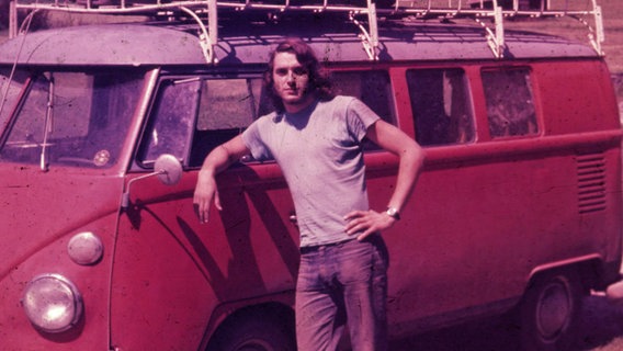 Eine alte Aufnahme zeigt den jungen Arved Fuchs vor einem roten VW-Bus. © Screenshot Foto: NDR
