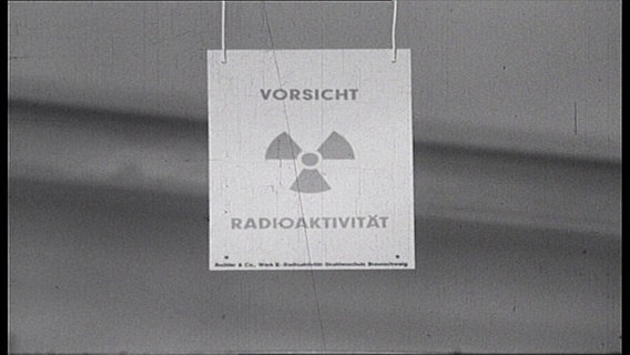 Eine Schild mit dem Schriftzug "Vorsicht Radioaktivität" hängt in einem Raum (Archivfoto, schwarzweiß). © NDR 