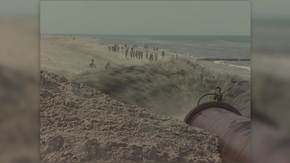 Eine historische Aufnahme zeigt Sandvorspülliung an einem Strand auf der Insel Sylt. © NDR 