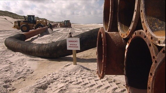Bagger verlegen Rohre zur Sandvorspülliung an einem Strand auf der Insel Sylt. © NDR 