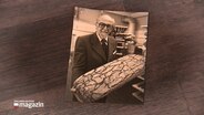 Ein Archiv-Foto zeigt Eberhard Paech mit einem großen Brot in den Händen in einer Bäckereihalle stehen. © NDR 