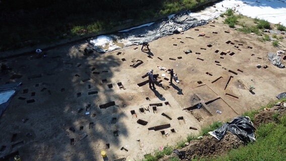 Archäologen steht bei einer Ausgrabung am Stadtrand von Lübeck. Archäologen steht bei einer Ausgrabung am Stadtrand von Lübeck. © NDR