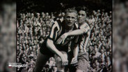 Ein historisches Foto zeigt die Handballlegende Hein Dahlinger bei einem Spiel im einem vollen Stadion. © NDR 