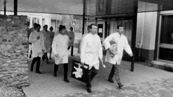 Ein Bild aus einer historischen Filmaufzeichnung, die Männer in Arztkitteln zeigt  Foto: Screenshot