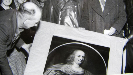 Schwarzweiß Aufnahme eines Mannes der ein Gemälde in den Händen hält © NDR Foto: Screenshot