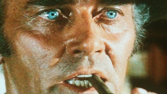 Der skrupellose Auftragskiller Frank (Henry Fonda) rätselt, was der Fremde, den sie "Mundharmonika" nennen, von ihm möchte. © NDR/BR/Kineos 