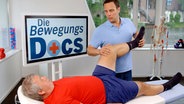 Orthopäde Dr. Sturm untersucht  einen Knie-Patienten auf er Liege. © NDR/nonfictionplanet 