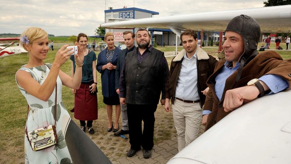 Hauptkommissar Paul Kleinert hat zum Geburtstag einen Rundflug über den Harz geschenkt bekommen, Klara macht ein Erinnerungsfoto. v.l.n.r. Klara (Wolke Hegenbarth), Inga Winter (Daniela Schulz), Dr. Gertrud Müller-Dietz (Alexa Maria Surholt), Jonas Wolter(Jan Niklas Berg), Ollie Ollenhauer (Christoph HagenDittmann), Pilot Arndt Simon (Martin Trippensee) , Paul Kleinert (Felix Eitner). Hauptkommissar Paul Kleinert hat zum Geburtstag einen Rundflug über den Harz geschenkt bekommen, Klara macht ein Erinnerungsfoto. v.l.n.r. Klara (Wolke Hegenbarth), Inga Winter (Daniela Schulz), Dr. Gertrud Müller-Dietz (Alexa Maria Surholt), Jonas Wolter(Jan Niklas Berg), Ollie Ollenhauer (Christoph HagenDittmann), Pilot Arndt Simon (Martin Trippensee) , Paul Kleinert (Felix Eitner). © NDR/ARD/Hardy Spitz