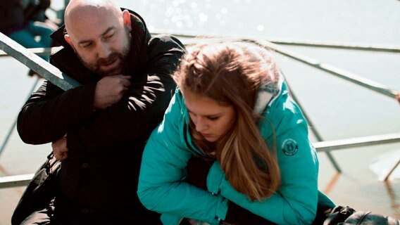 Robert (Loek Peters, li) und seine Tochter Britt (Marie-Mae van Zuilen, re) versuchen sich wachzuhalten, damit sie nicht vom Strommast fallen. © NDR/2016 JOCO Media/Menuet/EO/één 