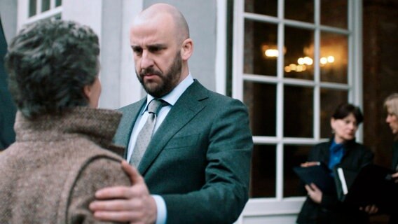 Sasja Wolbers (Simone Milsdochter, li) begrüßt den belgischen Premierminster André Verbeke (Tom van Dyck, re) zu Beginn des niederländisch-belgischen Verhandlungsgipfels, bei dem es um die Verteilung der europäischen Nothilfe geht. © NDR/2016 JOCO Media/Menuet/EO/één 