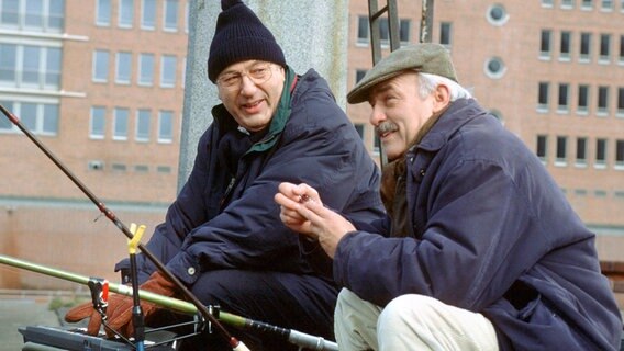 Die Kommissare Paul Stoever (Manfred Krug, links) und Peter Brockmöller (Charles Brauer, rechts) gehen nach Feierabend im Hamburger Hafen angeln. © NDR/T. Jander 