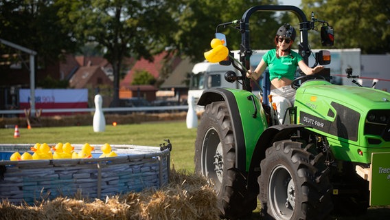 Jasmin Wagner beim Entenangeln auf einem Deutz-Fahr 4070 E. © NDR 