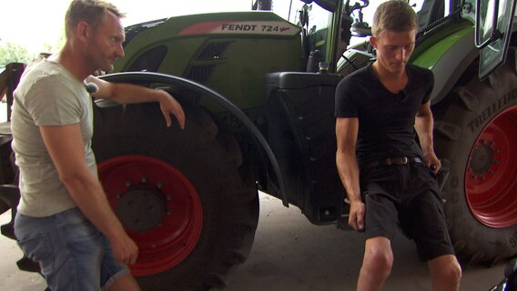 Sven beobachtet in Kettenkamp, wie sich Linus von einem extra eingebauten Lift in den Trecker heben lässt. © NDR 