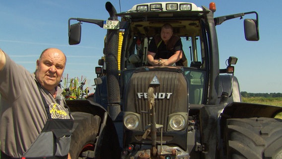 Dieter Annies erklärt seinem Mitarbeiter welche Strecker er mit dem Mähwerk zu fahren hat. © NDR 