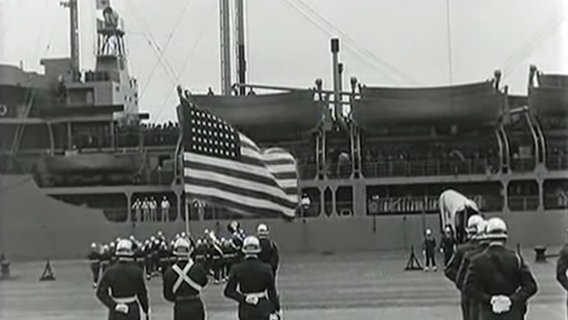 Amerikanische Soldaten stehen vor einem Kriegsschiff. © NDR 