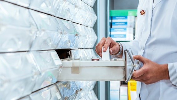 Ein Apotheker steht an einem Medikamentenregal © Colourbox Foto: Diego Cervo