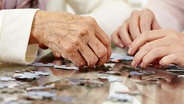 Senioren beim Puzzeln. © Fotolia.com Foto: Robert Kneschke