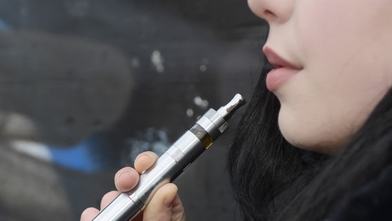 Eine Frau hält sich eine E-Zigarette an den Mund. © fotolia.com Foto:  tunedin
