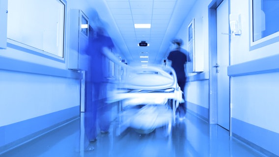 Krankenschwestern schieben ein Krankenhausbett durch eine Flur. © sudok1/fotolia Foto: sudok1