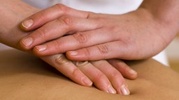 Hände, die einen Rücken massieren. © picture alliance Foto: 90072/KPA/Thomas
