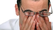Ein Mann reibt sich die Augen hinter seiner Brille. © Colourbox Foto: Phovoir