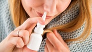 Eine junge Frau benutzt Nasenspray. © picture alliance / dpa Themendienst Foto: Christin Klose