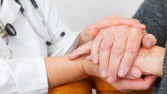 Arzt hält Hände einer Parkinson Patientin © fotolia Foto: Ocskay Mark
