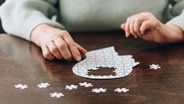 Hände einer Frau mit einem Puzzle eines Kopfes. © Colourbox Foto: #246329