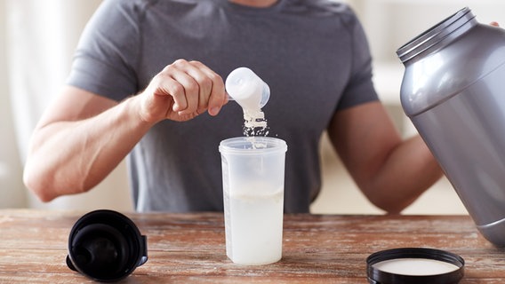 Ein Mann schüttet mit einem Portionierer Proteinpulver in einen Shaker. © Colourbox Foto: Syda Productions