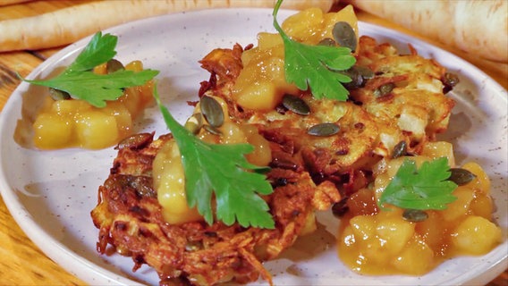 Petersilienwurzel-Rösti mit Birnen-Kompott auf einem Teller serviert. © NDR 