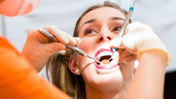 Eine Frau bekommt beim Zahnarzt eine professionelle Zahnreinigung. © fotolia.com Foto: Kzenon