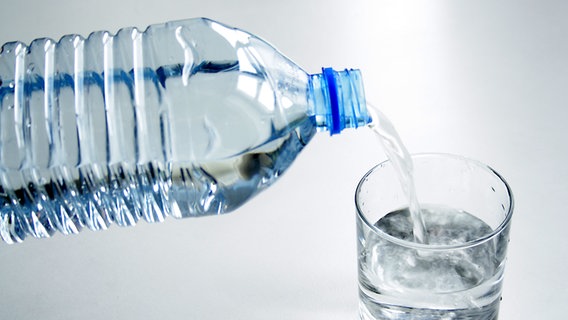 Aus einer Plastikflasche wird Wasser in ein Glas eingeschenkt. © Fotolia.com Foto: Kaesler Media