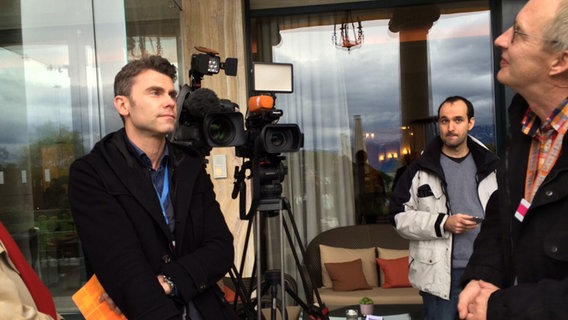 Daniel Hechler neben einer Kamera beim Interview  