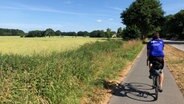 Radfahrer fährt auf einem Radweg durch die Natur. © NDR 