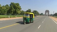 Ein Tuk-Tuk in den indischen Hauptstadt Neu Dehli vor dem India Gate  