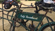 Ein altes Fahrrad mit der Aufschrift "Café Rosenhuset" © NDR 