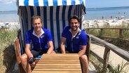 Christian Stichler und Ronald Schütze sitzen in einem Strandkorb in Scharbeutz. © NDR 