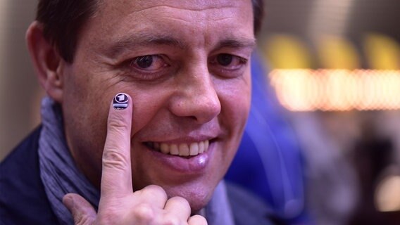 Korrespondent Uwe Schwering mit einem ARD-Logo als Tattoo auf dem Fingernagel  