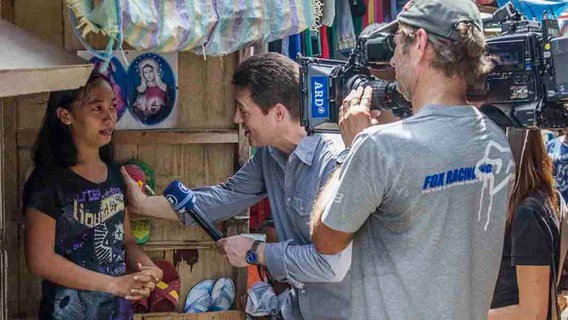 Korrespondent Uwe Schwering im Gespräch mit einer Frau in Tacloban  