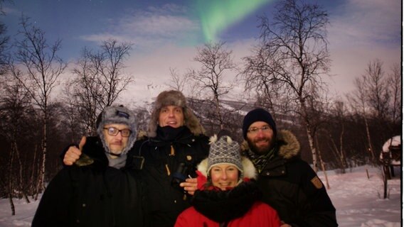 Das Team um ARD-Korrespondent Clas Oliver Richter (li.) vor einem Polarlicht.  