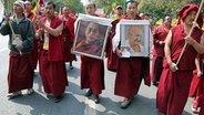 Tibetische Mönche protestieren mit Bildern des Dalai Lamas und Gandhis gegen das chinesische Regime. © dpa 