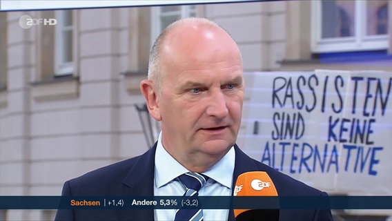 Während der ZDF-Liveübertragung von den Landtagswahlen halten Menschen ein Plakat mit der Aufschrift "Rassisten sind keine Alternative" in die Kamera. © ZDF 