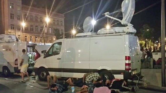 Flüchtlinge vor einem Fernseh-Übertragungswagen in Budapest. © NDR/ARD 