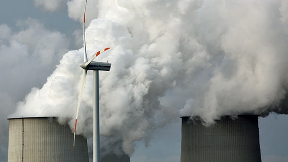 Hinter einem Windrad sind die Schlote eines Kohlekraftwerks zu sehen © picture-alliance/ZB Foto: Patrick Pleul