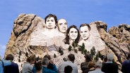 Die Gesichter von vier deutschen Virologen in das Mount Rushmore National Memorial gesetzt. © NDR 