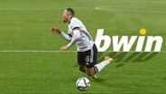 Lukas Nmecha vor Bwin-Logo  